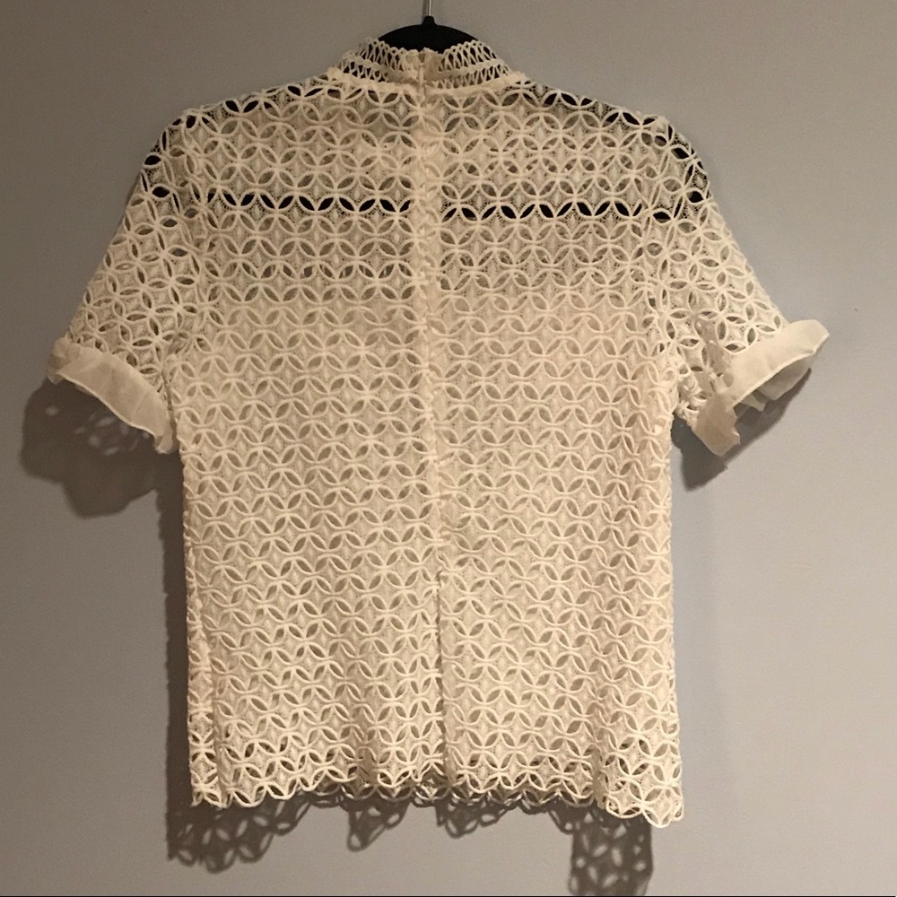 Women’s white patterned short collared top.